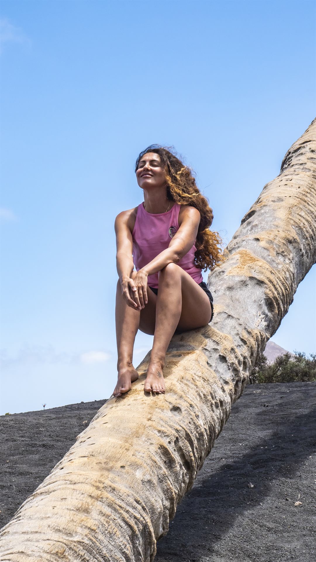 Catherine sitting on a palm trunk